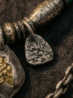 Detail close-up of vintage Tibetan script carved metal charm pendant
