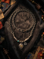 Handcrafted Tibetan vintage necklace with eagle totem pendant and turquoise bead on dark velvet