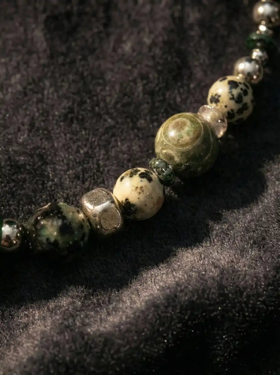 Macro detail of green agate, spotted jasper beads, and metallic cube spacer