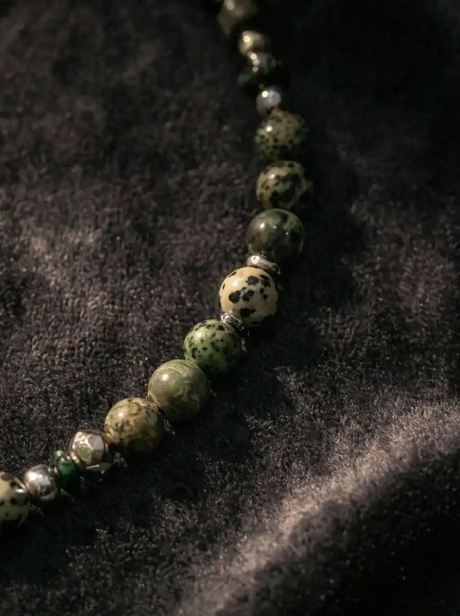 Close-up strand of natural green moss agate and spotted stone beads