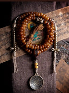 Full lay flat view of 108 yak bone bead necklace with Vajra counters, Dzi bead, and Bagua charm
